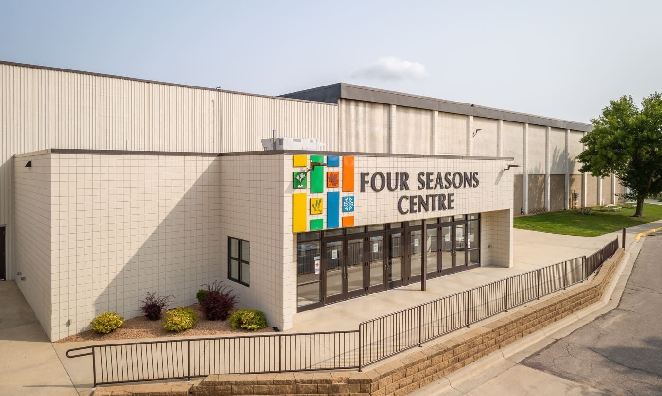Exterior view of the Four Seasons Centre, showing the main entrance with colorful seasonal icons on the wall.